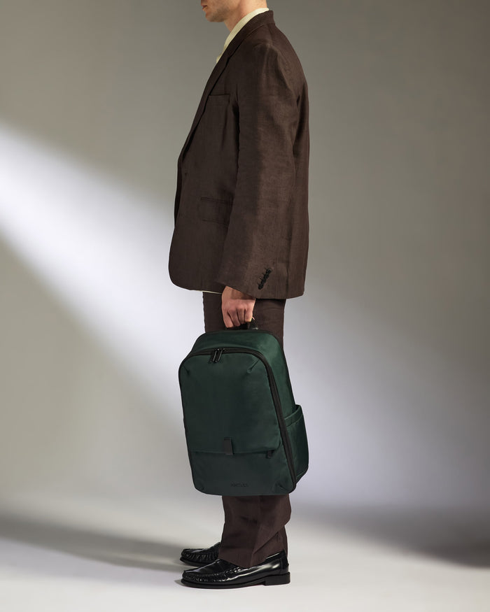 a man in a suit holding a green bag