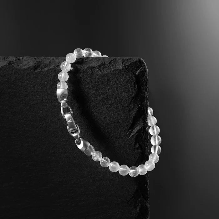 Beaded bracelet on a dark stone surface with a black background