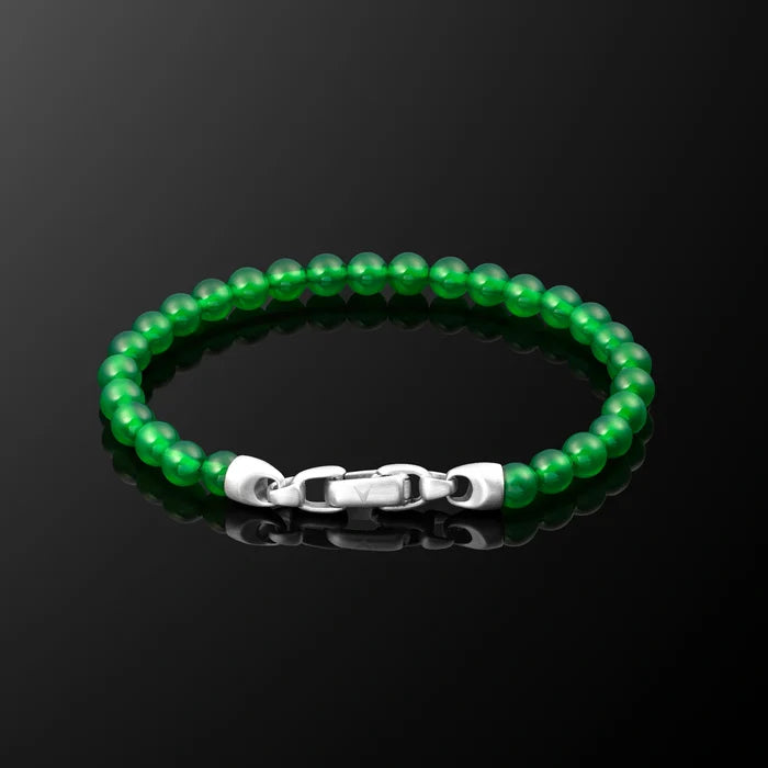 Green beaded bracelet with a silver clasp on a black background