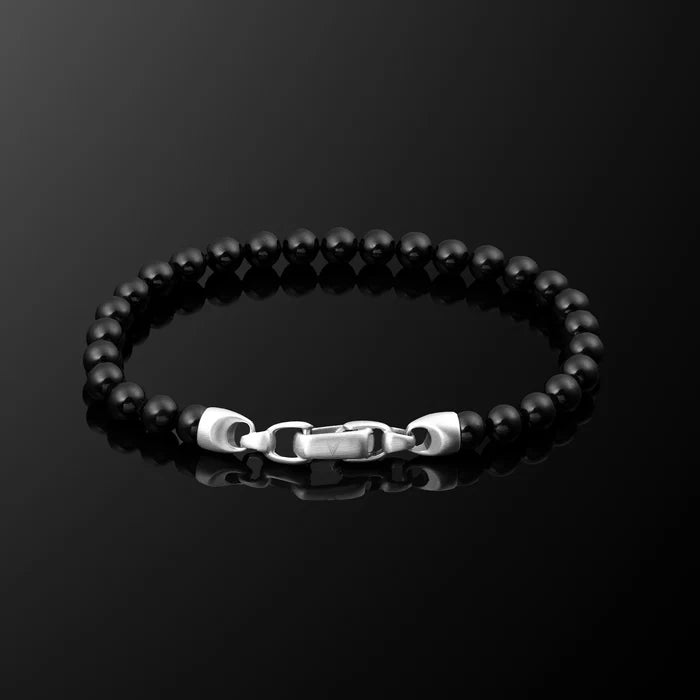 Black beaded bracelet with a silver clasp on a black background