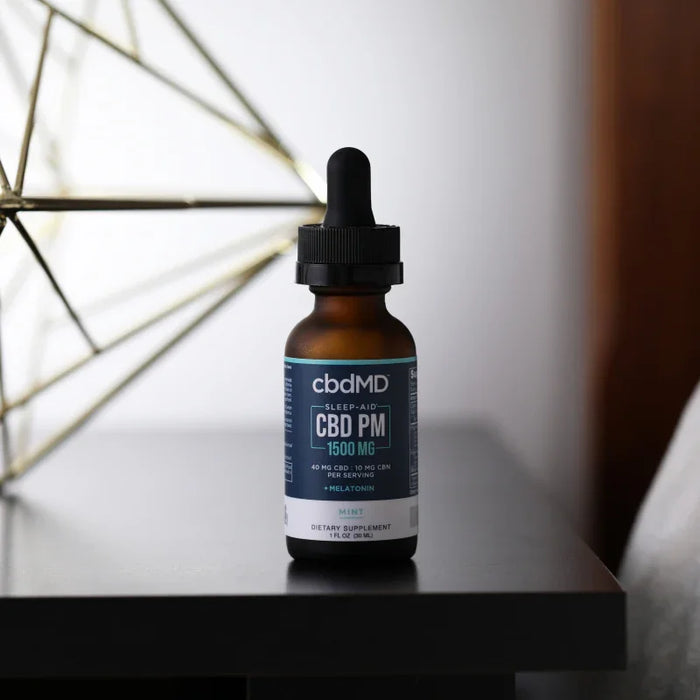 CBD PM 1500mg sleep aid tincture with melatonin and mint flavor on a table