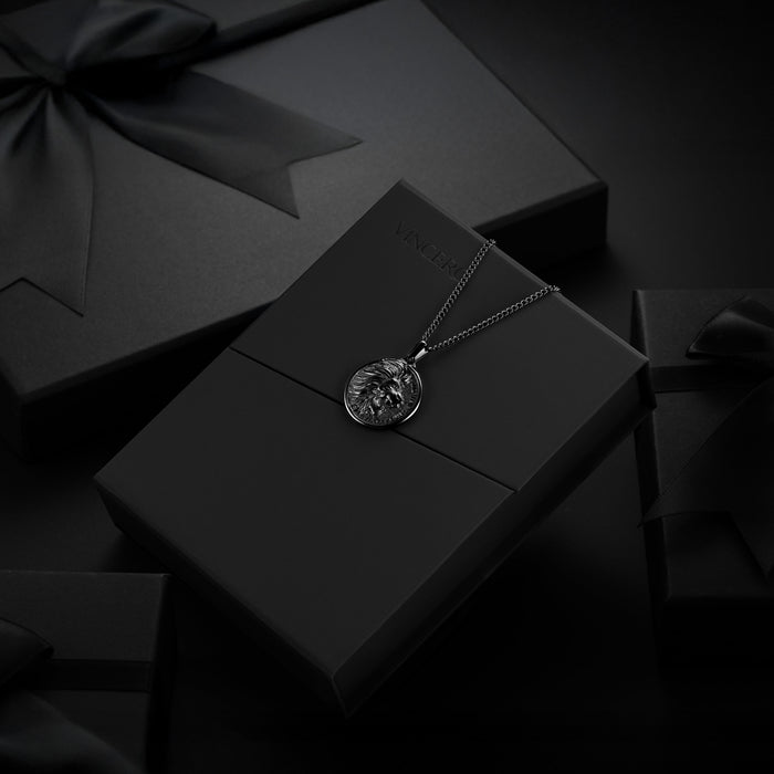Silver necklace with a pendant on a black box against a dark background