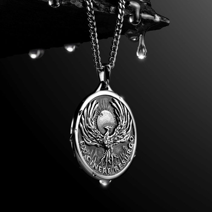 Silver necklace with a pendant featuring a phoenix design on a dark background