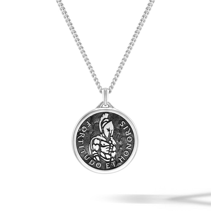 Silver necklace with a round pendant on a white background