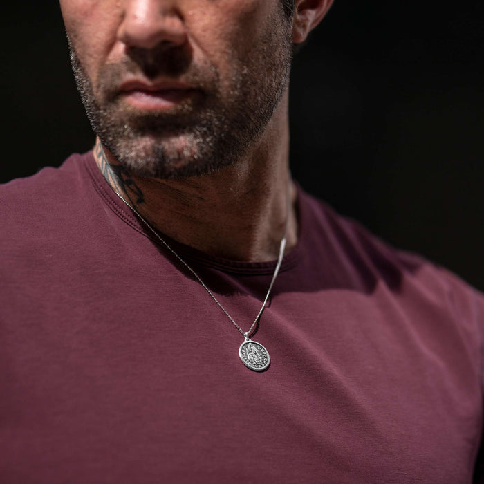 Man wearing silver chain necklace with silver Spartan pendant