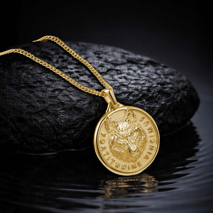 Gold necklace with a pendant featuring a wolf design on a dark background
