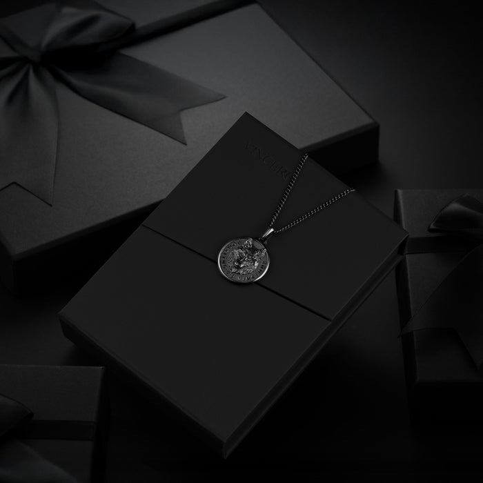 Black wolf pendant for men on black packaging.