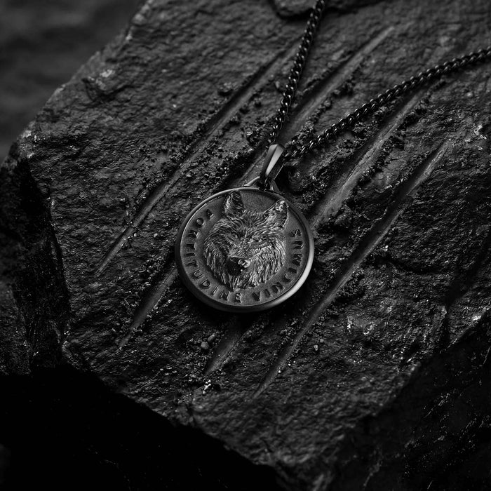 Black wolf pendant for man on black lava rock with scratches