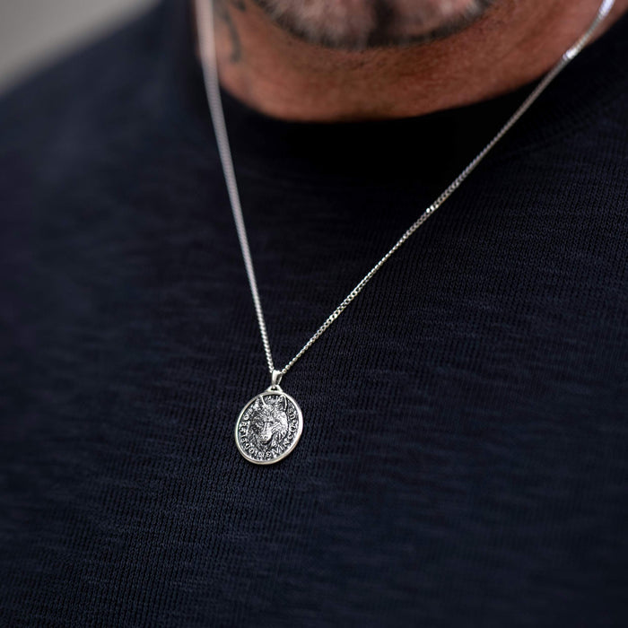 Man wearing silver chan necklace with silver wolf pendant