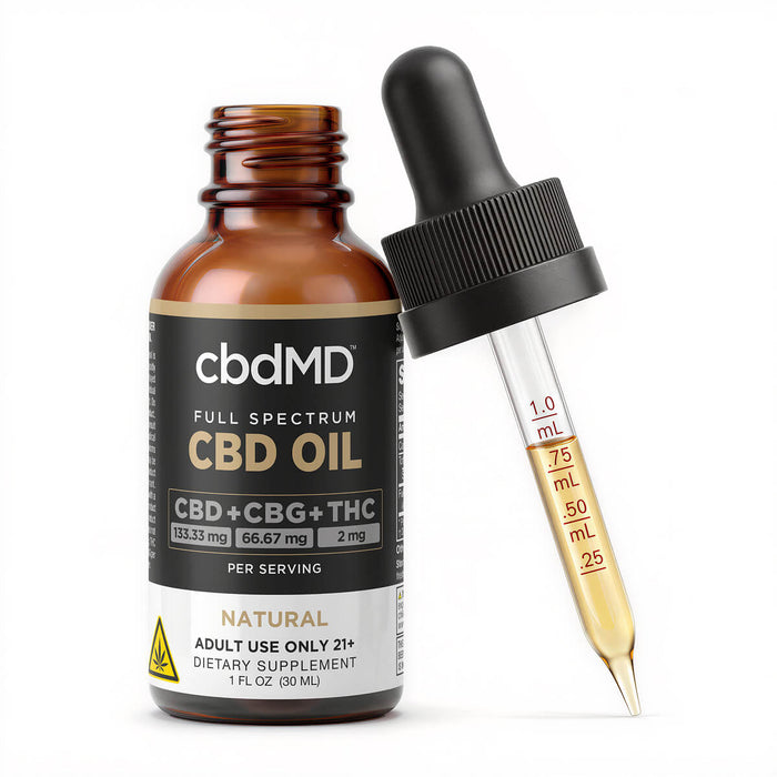 An amber glass bottle of cbdMD Full Spectrum CBD Oil next to a black dropper with a clear glass pipette containing golden oil, on a white background.