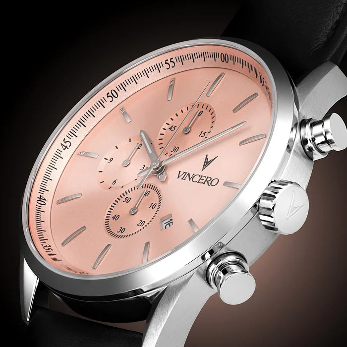 Luxury watch with pink dial and silver case on a dark background