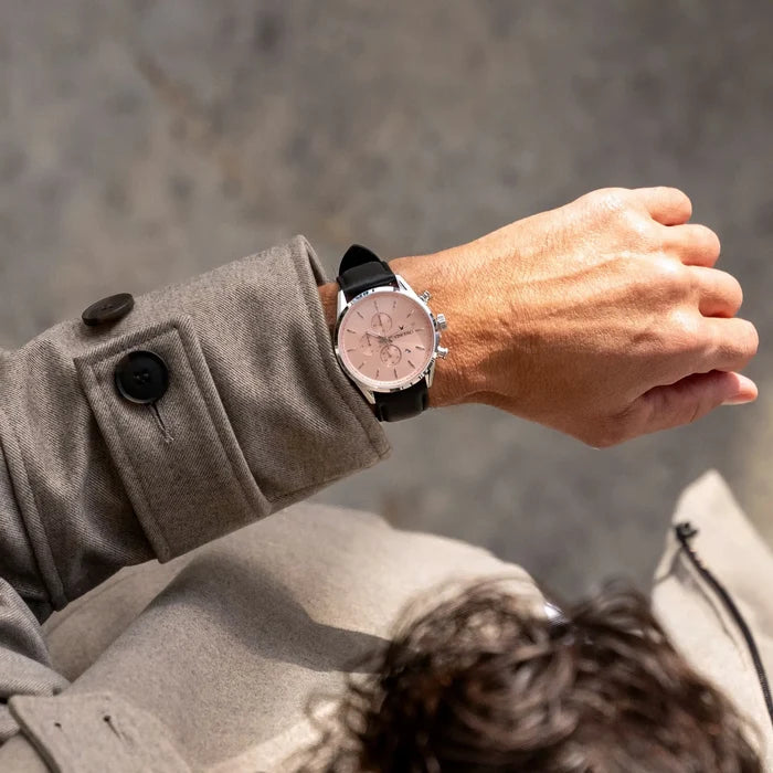 Person wearing a watch on a gray background