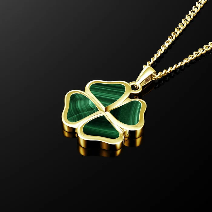 A gold-plated four-leaf clover pendant necklace with green malachite inlay, shown on a reflective black background.