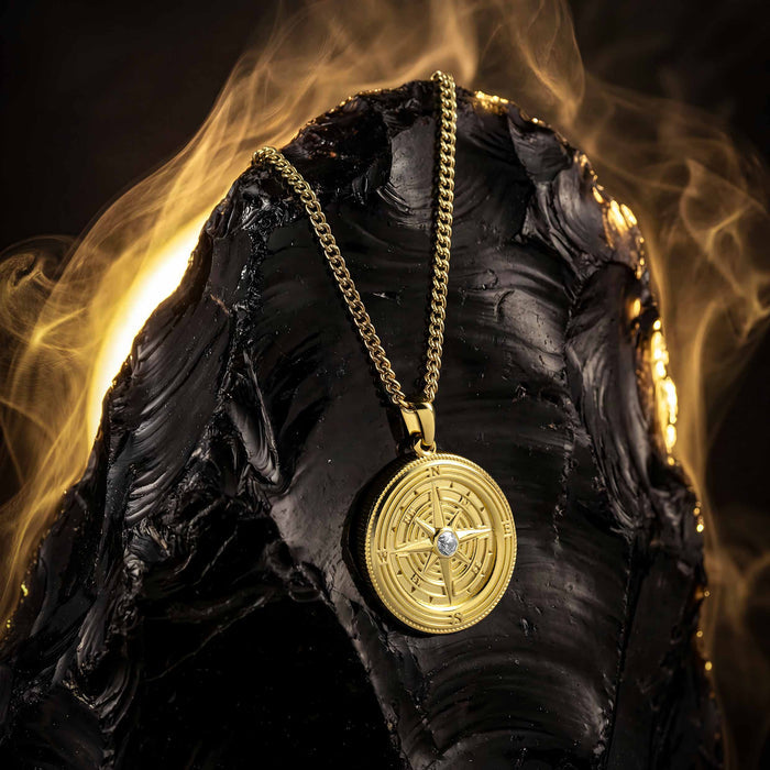 Gold necklace with a pendant on a dark background