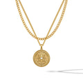 A gold-colored compass pendant necklace with a central sapphire stone, featuring a classic curb chain design.