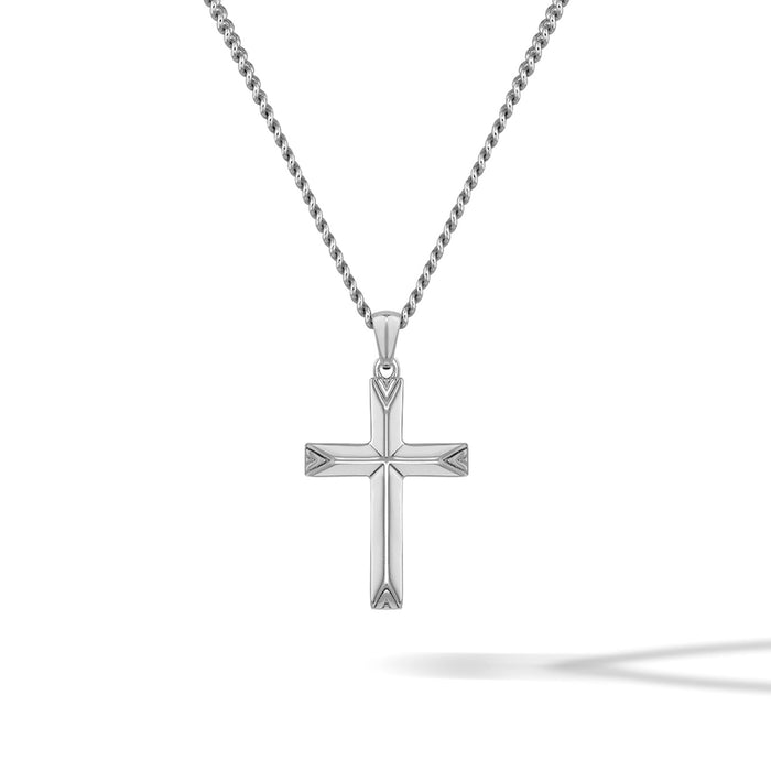 Silver cross pendant on a chain against a white background