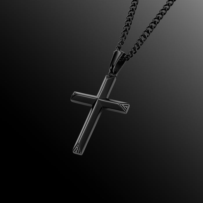 Black cross pendant on a chain against a dark background
