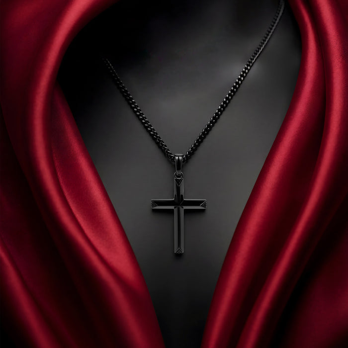 Black cross necklace on a dark background with red fabric