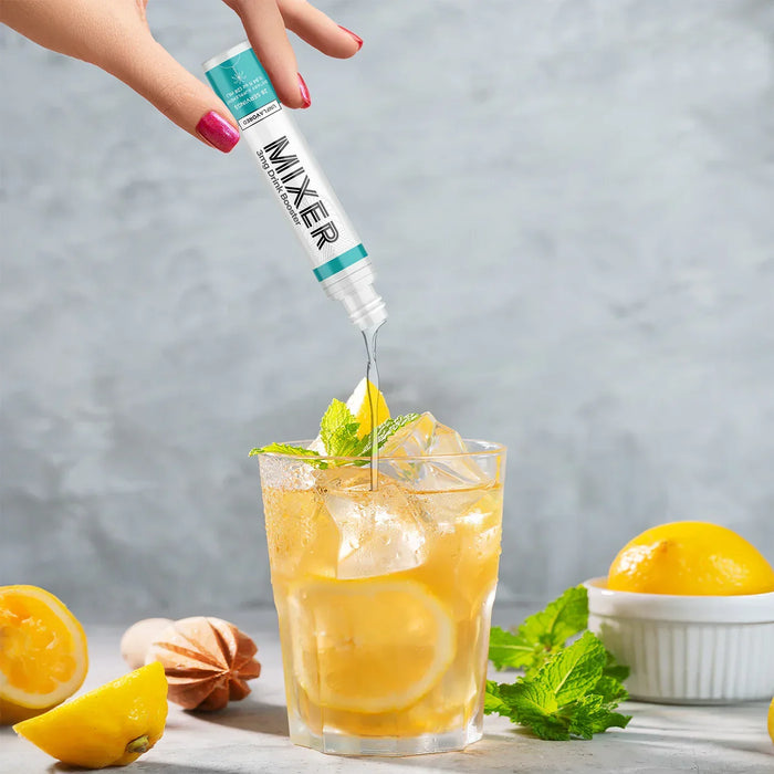 Unflavored mixer liquid being poured into a lemon iced tea with fresh mint and lemons