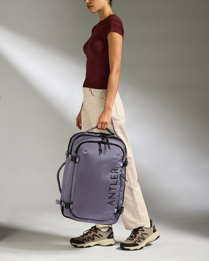 a woman walking with a purple suitcase