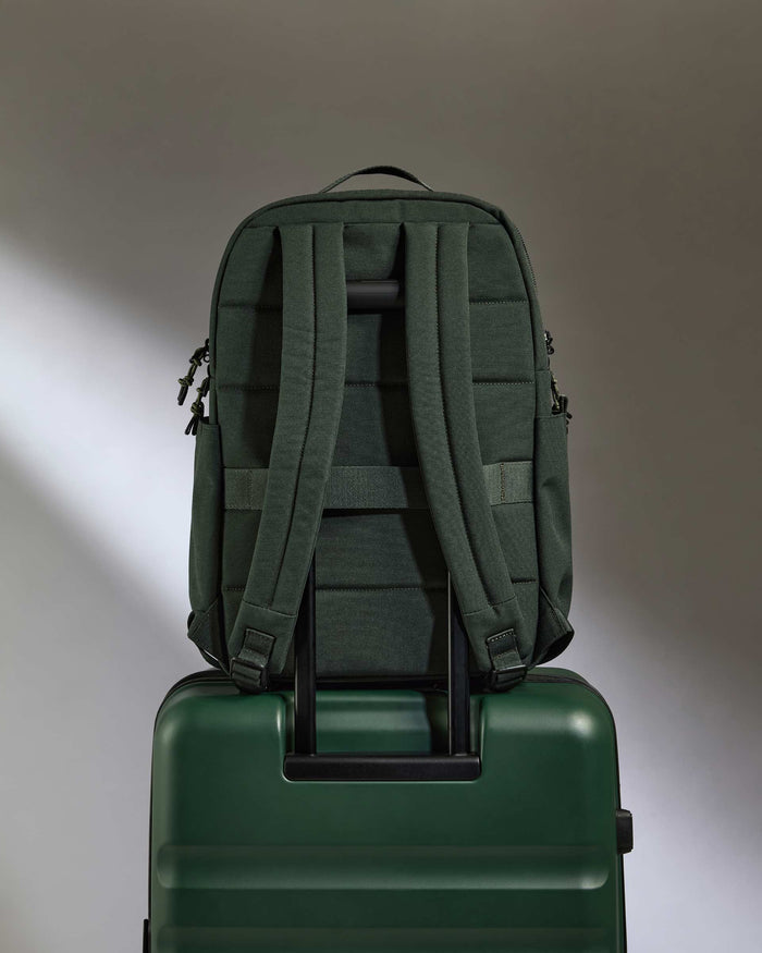 a green backpack on a suitcase