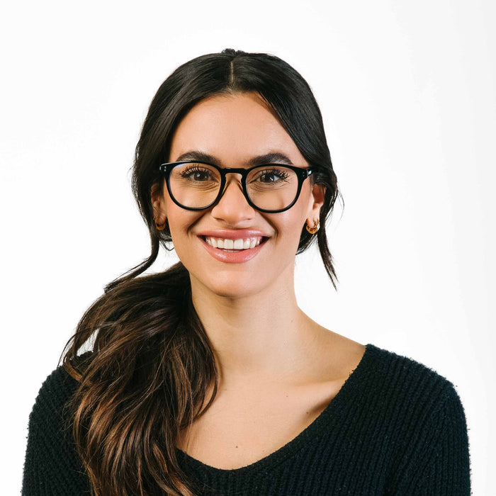 Woman wearing glasses and a black sweater on a white background