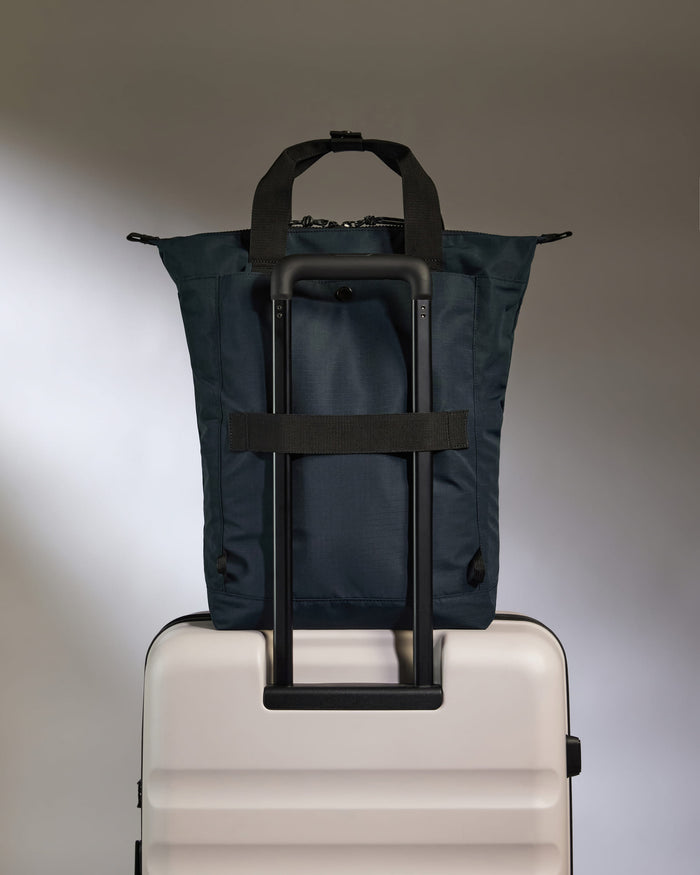 a blue bag on top of a white suitcase