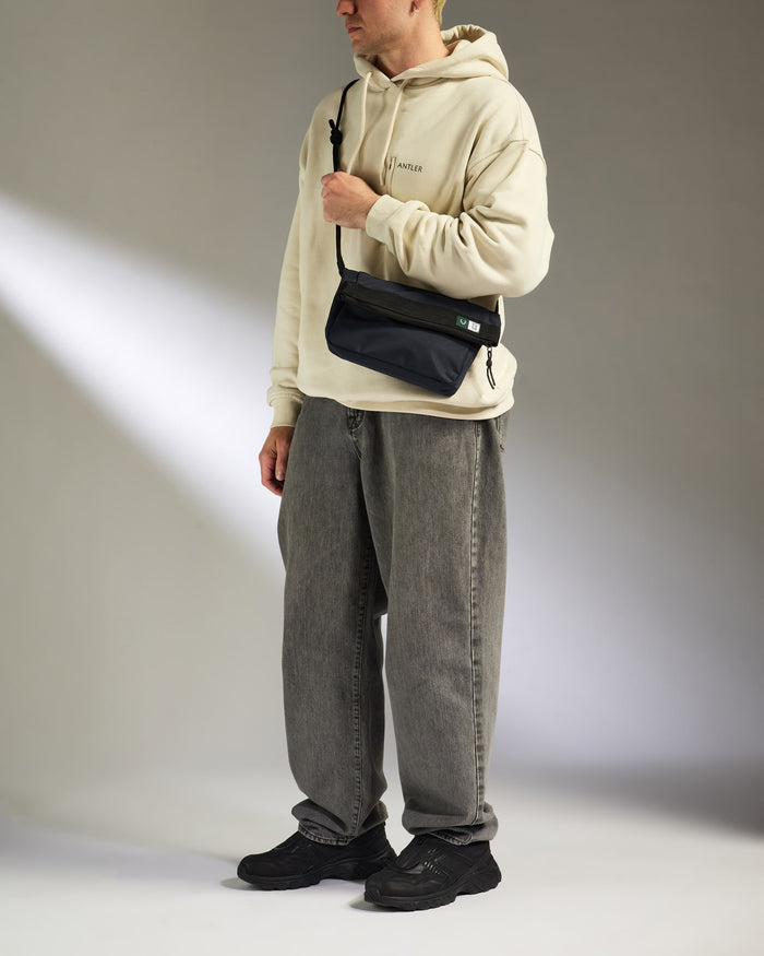 a man wearing a white sweatshirt and grey pants