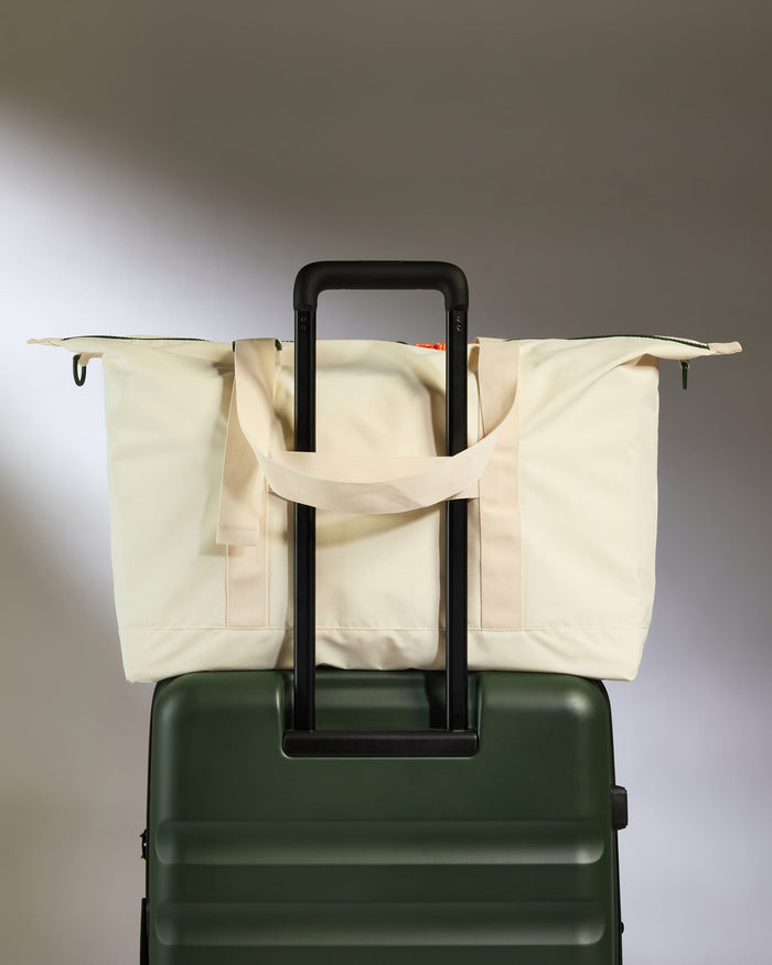 a green and white bag on top of a green suitcase