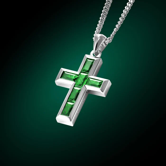 Silver cross pendant with red stones on a chain against a black background