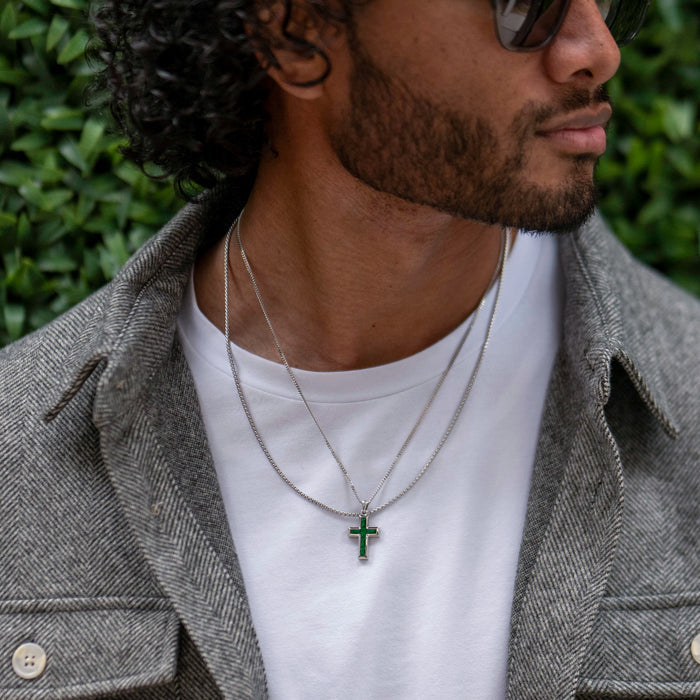 Silver cross pendant with red stones on a chain