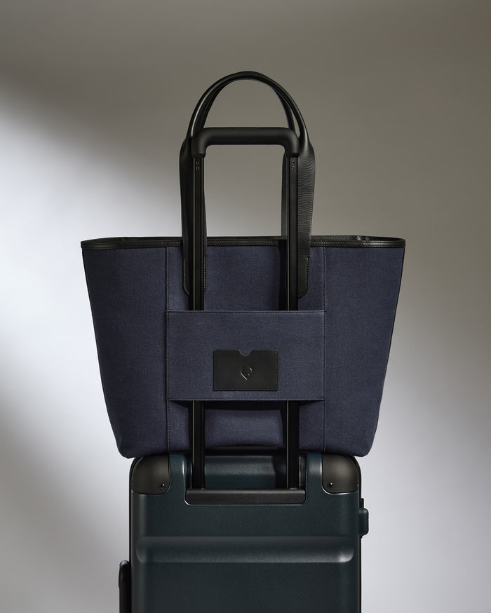 a blue bag on top of a suitcase