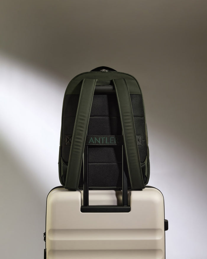 a backpack on top of a white suitcase