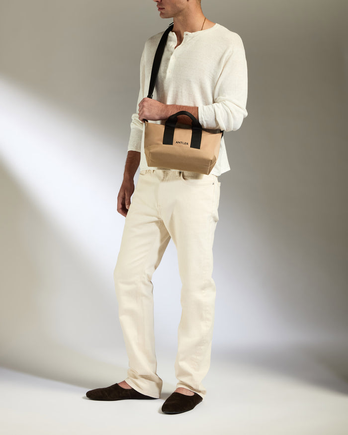 a man in white clothes holding a bag