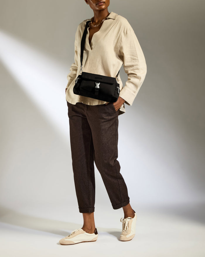 a woman in a white shirt and brown pants