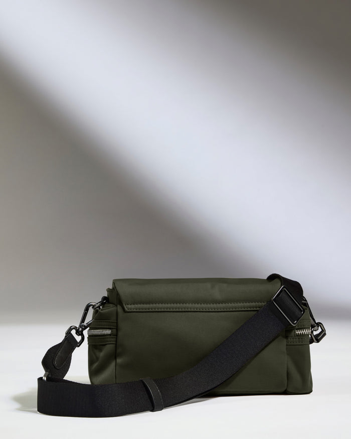 a green bag with a black strap