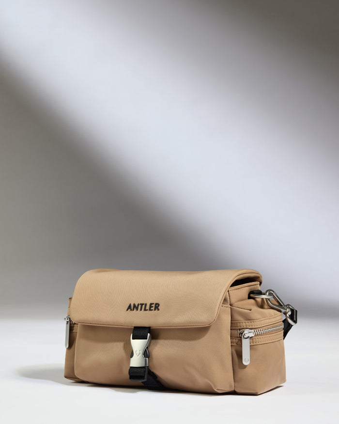 a tan bag with black straps
