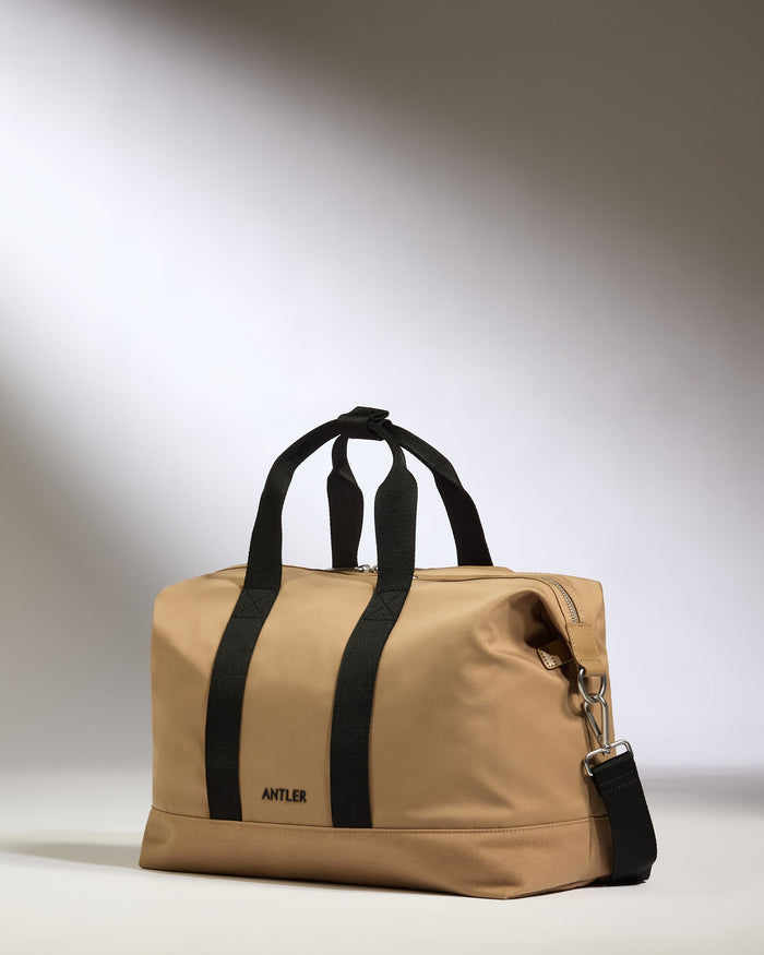 a tan bag with black straps