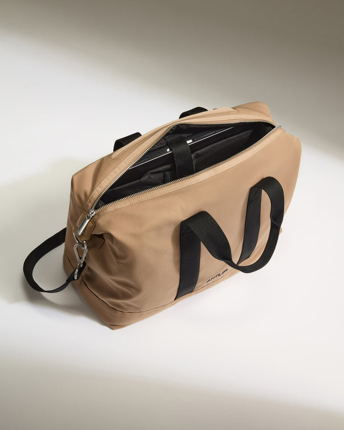 a tan bag with black straps