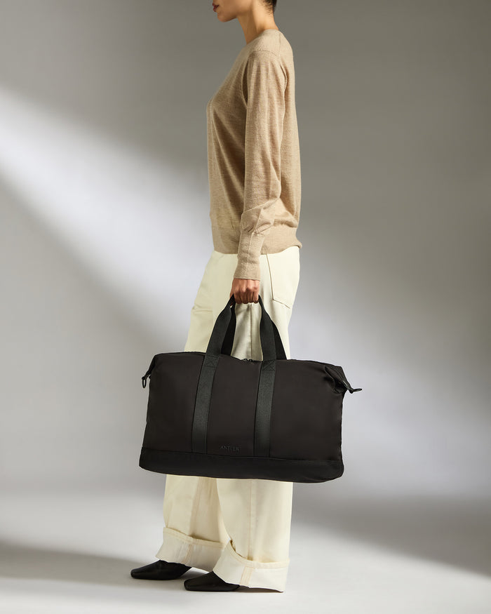 a woman holding a black bag