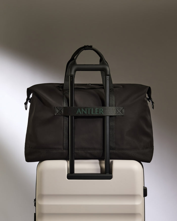 a black bag on a white suitcase
