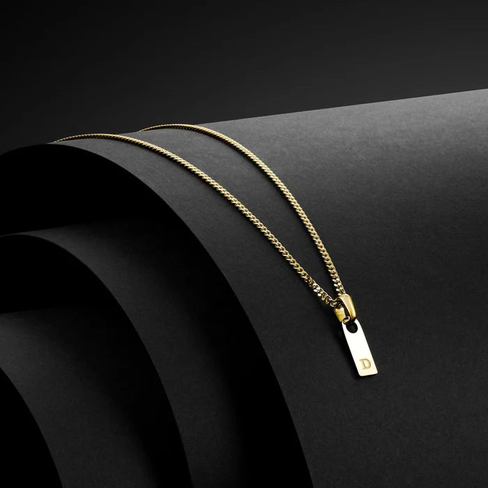 Gold necklace with a tag on a black background