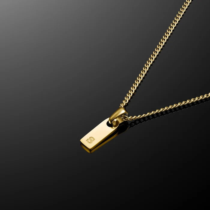 Gold necklace with a tag on a black background