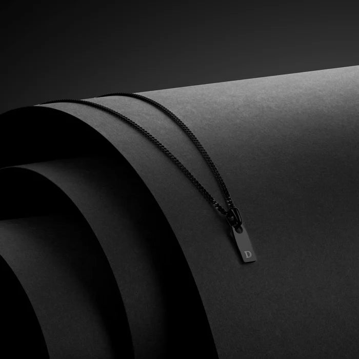 Black zipper on a black surface with a brand logo.