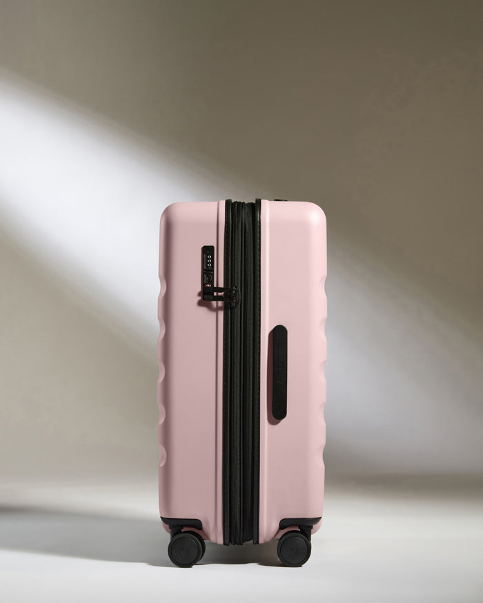 a pink suitcase with wheels