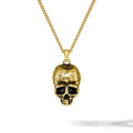 Gold skull pendant necklace on a white background