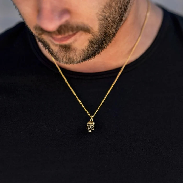 Gold chain necklace with a skull pendant