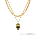 Gold chain necklace with a skull pendant on a white background