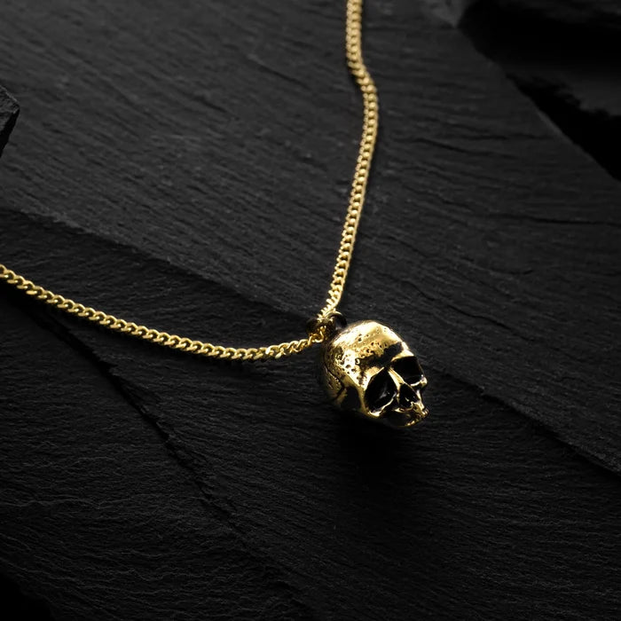 Gold chain necklace with a skull pendant