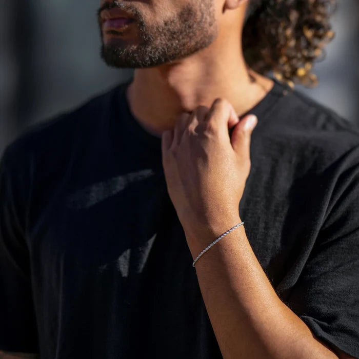 Person wearing a black shirt with another hand touching their neck